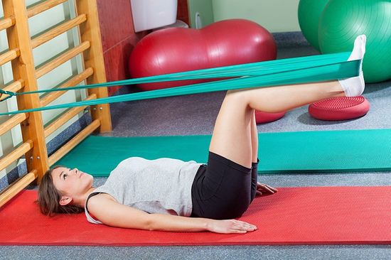 Girl stretching legs with elastic band Girl stretching legs with elastic band